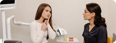 Dentist discussing jaw pain symptoms with a patient during consultation