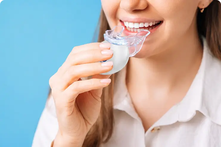 Patient holding a custom oral splint for TMJ treatment