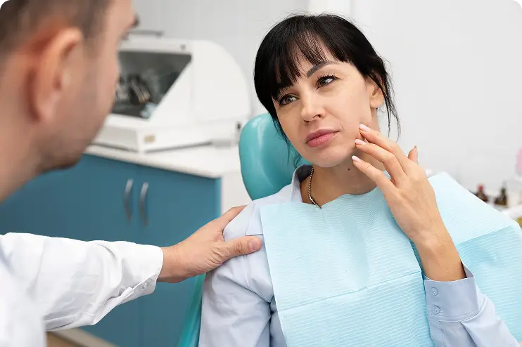 Dentist evaluating a patient's jaw during tmj consultation