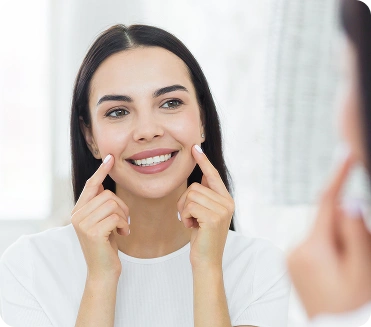 Woman pointing to her smile after teeth straightening